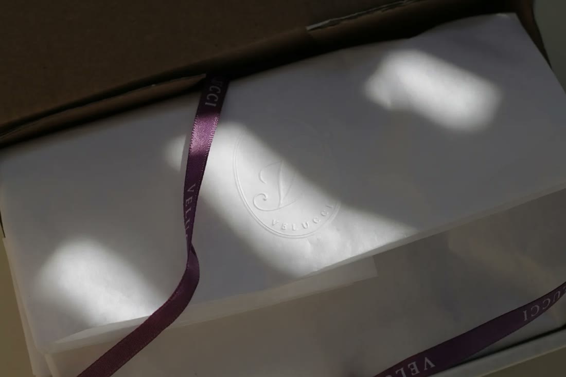 Tissue paper with an embossed mark and a ribbon in a streak of sunlight